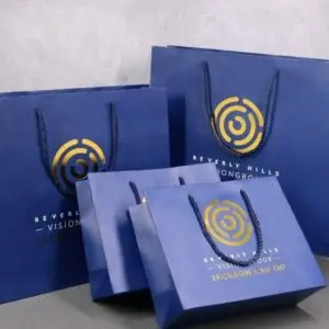 Set of custom printed blue paper gift bags in various sizes for luxury brand packaging