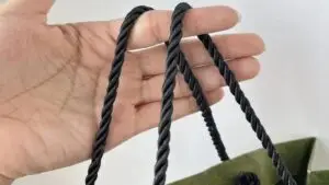 Close-up of durable braided cotton rope handles on custom retail paper bag demonstrating high load-bearing capacity