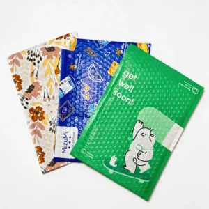 Collection of high-precision multi-color printed co-extruded bubble mailers in floral, blue cosmic, and green cartoon bear designs