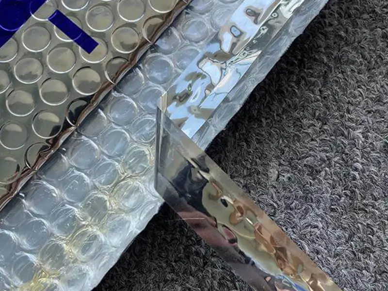 Macro detail of peel-and-seal adhesive flap on metallic holographic bubble padded envelope