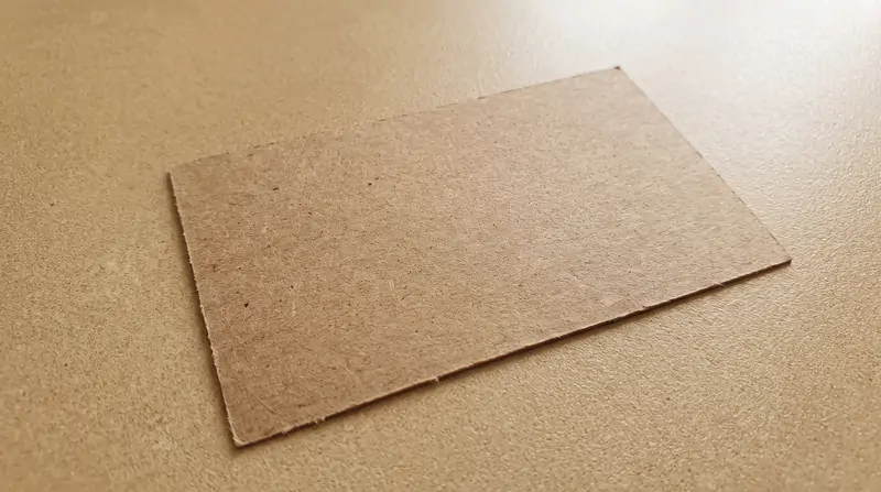 Macro texture of 350gsm natural kraft paperboard showing natural wood fibers